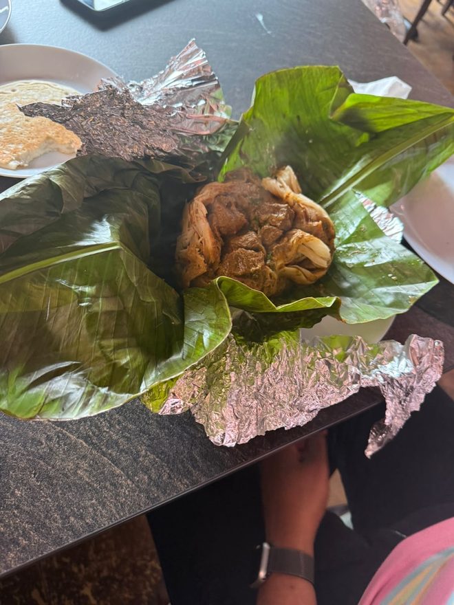 Banana leaf parcel being unwrapped at the table