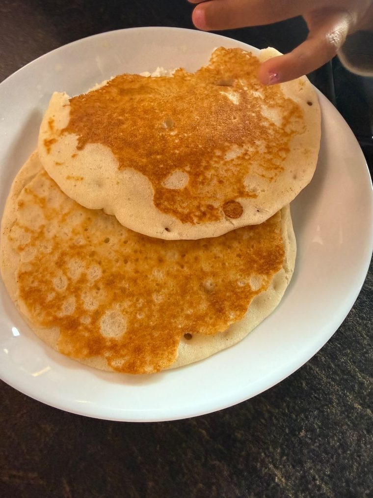 A stack of golden appam on a white plate